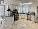 Kitchen featuring stainless steel appliances, a breakfast bar area, a peninsula, white cabinets, and crown molding - 2056 Hadfield Court, Burlington, ON  - Indoor Photo Showing Kitchen With Upgraded Kitchen 