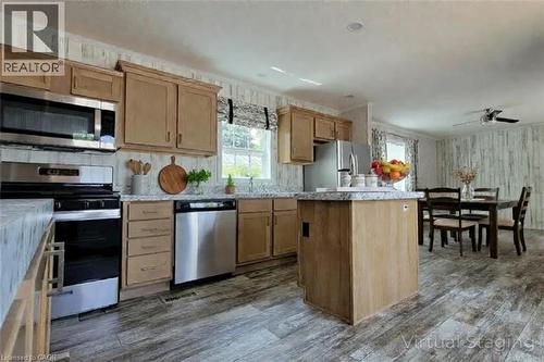 Kitchen featuring stainless steel appliances, light countertops, ceiling fan, dark wood-style floors, and a center island - 77 Park Lane, Flamborough, ON - Indoor Photo Showing Kitchen