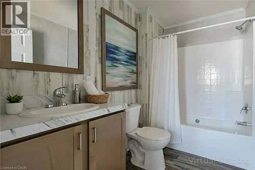 Full bathroom with ornamental molding, vanity, shower / bathtub combination with curtain, wood finished floors, and wallpapered walls - 77 Park Lane, Flamborough, ON - Indoor Photo Showing Bathroom