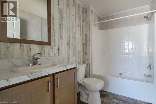 Full bathroom featuring toilet, ornamental molding, vanity, shower / bath combination, and wood finished floors - 77 Park Lane, Flamborough, ON - Indoor Photo Showing Bathroom