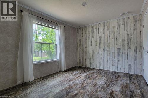 Empty room with wood finished floors, crown molding, and a textured ceiling - 77 Park Lane, Flamborough, ON - Indoor Photo Showing Other Room