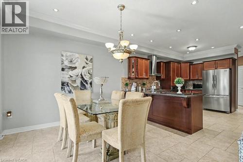 Dining room with ornamental molding, hanging lights, a tray ceiling, and light tile patterned flooring - 284 Normanhurst Avenue, Hamilton, ON - Indoor Photo Showing Dining Room