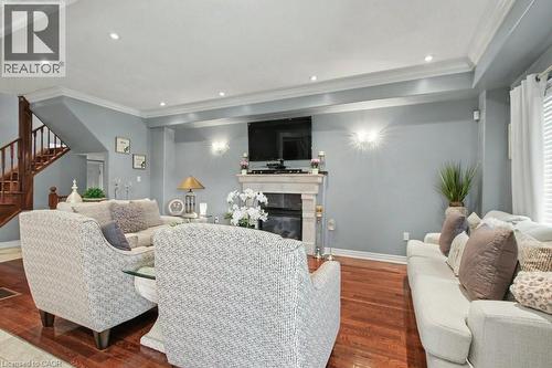 Living area with wood finished floors, crown molding, a glass covered fireplace, and recessed lighting - 284 Normanhurst Avenue, Hamilton, ON - Indoor With Fireplace