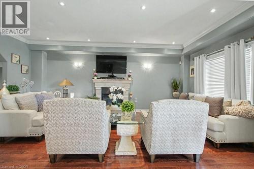 Living area with ornamental molding, dark wood-style flooring, a glass covered fireplace, and recessed lighting - 284 Normanhurst Avenue, Hamilton, ON - Indoor Photo Showing Living Room With Fireplace