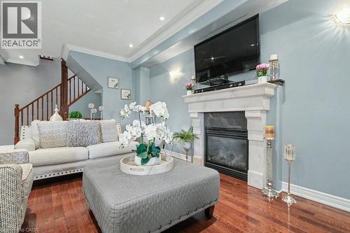 Living area featuring dark wood-style flooring, crown molding, a high end fireplace, and recessed lighting - 284 Normanhurst Avenue, Hamilton, ON - Indoor Photo Showing Living Room With Fireplace
