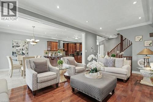 Living area with suspended lighting, ornamental molding, and dark wood-style floors - 284 Normanhurst Avenue, Hamilton, ON - Indoor Photo Showing Living Room