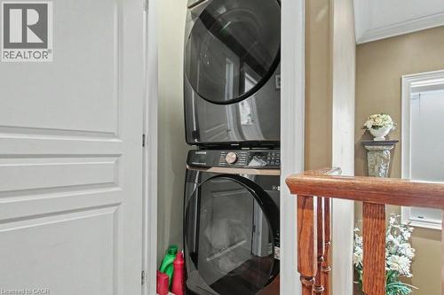 Laundry area with stacked washer / drying machine and a wall mounted mini split - 284 Normanhurst Avenue, Hamilton, ON - Indoor Photo Showing Laundry Room