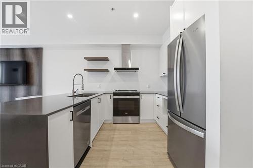 Kitchen featuring a peninsula, stainless steel appliances, white cabinets, open shelves, and recessed lighting - 120 Springvalley Crescent Unit# 203, Hamilton, ON - Indoor Photo Showing Kitchen With Stainless Steel Kitchen With Upgraded Kitchen