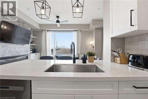 Kitchen featuring backsplash, white cabinetry, light stone countertops, ceiling fan, and dishwasher - 120 Springvalley Crescent Unit# 203, Hamilton, ON - Indoor Photo Showing Kitchen With Upgraded Kitchen