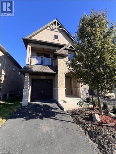 View of front facade with stone siding, a balcony, driveway, and a garage - 1165 West 5Th Street, Hamilton, ON - Outdoor