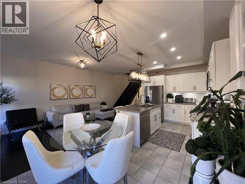 Dining space with a chandelier and light tile patterned flooring - 1165 West 5Th Street, Hamilton, ON - Indoor Photo Showing Dining Room