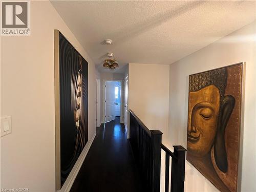 Hallway with a textured ceiling, an upstairs landing, and dark wood finished floors - 1165 West 5Th Street, Hamilton, ON - Indoor Photo Showing Other Room