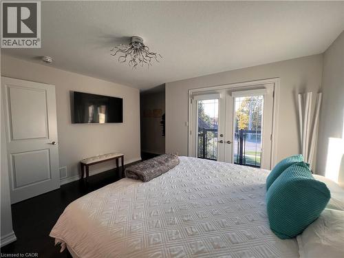 Bedroom with french doors, access to exterior, a textured ceiling, and dark wood-style floors - 1165 West 5Th Street, Hamilton, ON - Indoor Photo Showing Bedroom