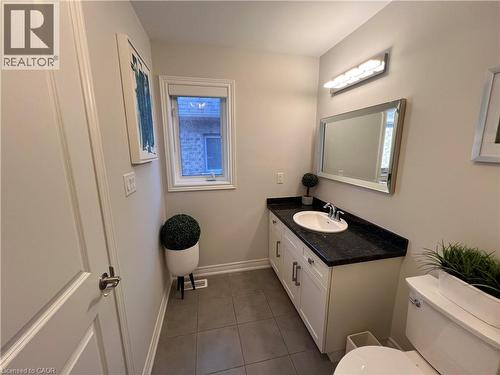Half bathroom featuring vanity and dark tile patterned floors - 1165 West 5Th Street, Hamilton, ON - Indoor Photo Showing Bathroom