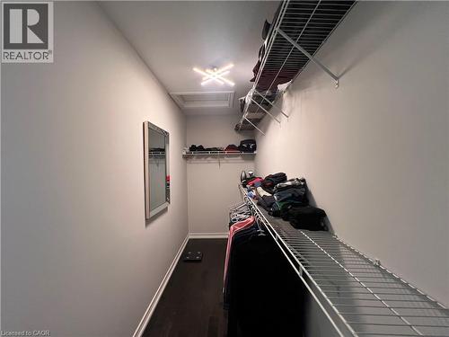 Walk in closet featuring dark wood finished floors and attic access - 1165 West 5Th Street, Hamilton, ON - Indoor
