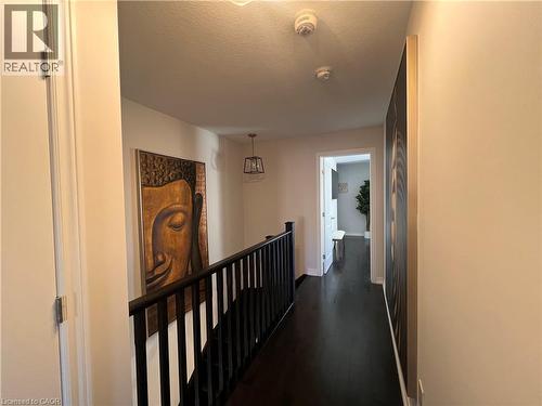 Hallway featuring dark wood-type flooring, an upstairs landing, and a textured ceiling - 1165 West 5Th Street, Hamilton, ON - Indoor Photo Showing Other Room