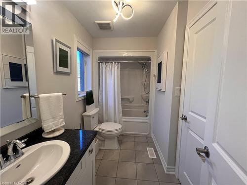 Bathroom with shower / bath combo with shower curtain, vanity, and dark tile patterned floors - 1165 West 5Th Street, Hamilton, ON - Indoor Photo Showing Bathroom