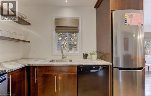 Kitchen with freestanding refrigerator, black dishwasher, light stone counters, open shelves, and wood finish cabinets - 306 Roxton Drive, Waterloo, ON - Indoor Photo Showing Kitchen