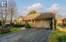 View of front of property featuring a garage, asphalt driveway, covered porch, a front yard, and brick siding - 306 Roxton Drive, Waterloo, ON  - Outdoor 