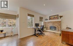 Home office with light wood-style floors, a fireplace, and recessed lighting - 
