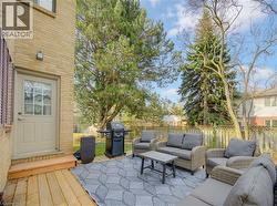 Fenced backyard featuring grilling area, outdoor furniture, and a wooden deck - 