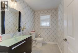 Half bathroom featuring wallpapered walls and vanity - 