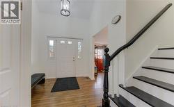 Foyer entrance with hardwood / wood-style flooring and a high ceiling - 