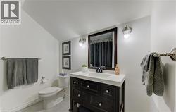 Full bathroom with vanity, light tile patterned flooring, a shower with curtain, and lofted ceiling - 