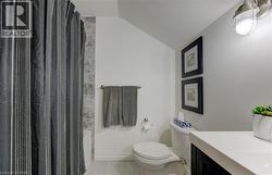 Full bathroom with vaulted ceiling, vanity, shower / bathtub combination with curtain, and light tile patterned floors - 