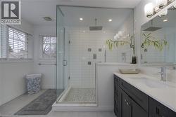 Full bath featuring vanity, a stall shower, recessed lighting, and light tile patterned floors - 