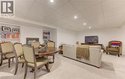 Dining space with a paneled ceiling, built in features, a fireplace, light carpet, and recessed lighting - 