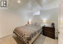 Bedroom with light colored carpet and a drop ceiling - 