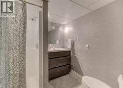 Full bathroom featuring a stall shower, vanity, and light tile patterned floors - 