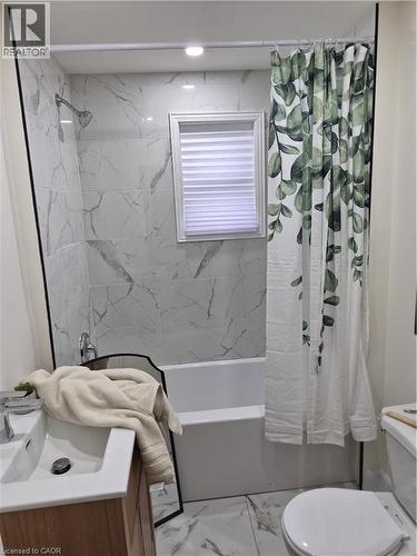 Bathroom featuring vanity, marble finish floors, and shower / bathtub combination with curtain - 7 Stapleton Avenue, Hamilton, ON - Indoor Photo Showing Bathroom