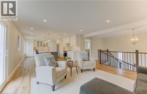 Living room featuring hanging lights, light wood-style flooring, and crown molding - 395 Warrington Drive, Waterloo, ON - Indoor Photo Showing Living Room