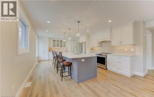 Kitchen with stainless steel appliances, a breakfast bar, decorative backsplash, pendant lighting, and a large island - 395 Warrington Drive, Waterloo, ON - Indoor Photo Showing Kitchen With Upgraded Kitchen