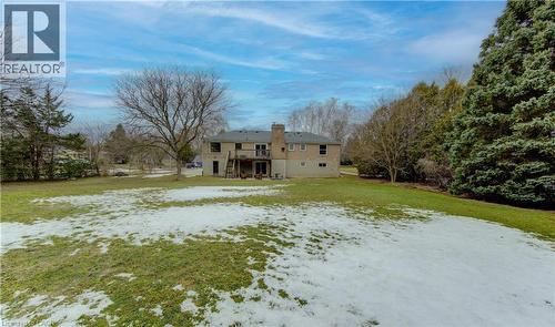 Snow covered rear of property featuring a lawn, a deck, and a chimney - 395 Warrington Drive, Waterloo, ON - Outdoor
