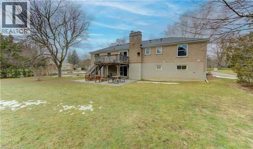 Back of house with a patio area, a chimney, a deck, and a lawn - 395 Warrington Drive, Waterloo, ON - Outdoor With Deck Patio Veranda