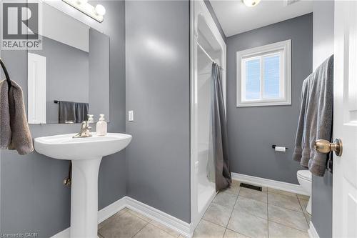 Full bath with a shower with shower curtain and light tile patterned floors - 160 Wallace Avenue S, Welland, ON - Indoor Photo Showing Bathroom