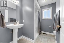 Full bath with a shower with shower curtain and light tile patterned floors - 