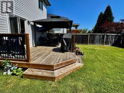 Wooden deck featuring a fenced backyard, a gazebo, and area for grilling - 