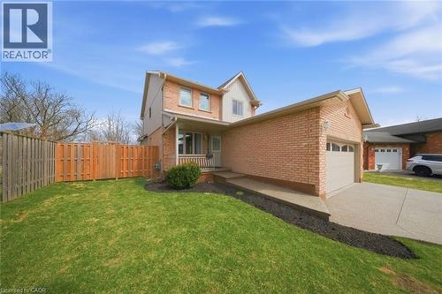 View of front facade featuring a garage, concrete driveway, brick siding, and board and batten siding - 200 Morrison Drive, Caledonia, ON - Outdoor