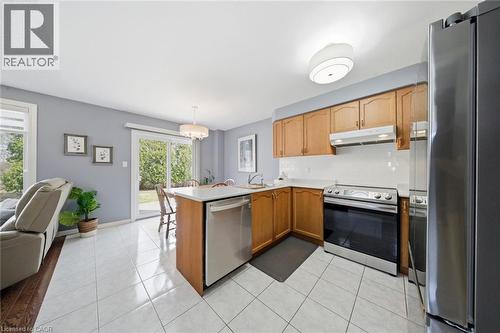Kitchen with stainless steel appliances, light countertops, open floor plan, light tile patterned floors, and a peninsula - 200 Morrison Drive, Caledonia, ON - Indoor Photo Showing Kitchen