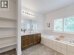 Bathroom with a bath, vanity, and light tile patterned flooring - 