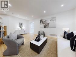 Living room featuring arched walkways, light wood-style floors, and recessed lighting - 