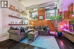 Living room with brick wall and dark wood finished floors - 