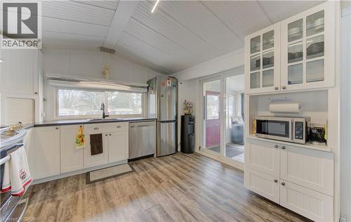 Kitchen featuring white cabinets, stainless steel appliances, light wood finished floors, and glass fronted cabinets - 580 Beaver Creek Road Unit# 11, Waterloo, ON - Indoor Photo Showing Kitchen