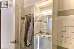 Bathroom with tile walls, vanity, and a shower with curtain - 