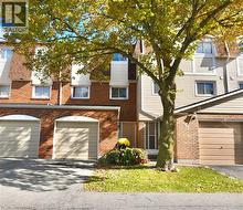 View of front of home with driveway, an attached garage, and brick siding - 