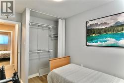 Bedroom featuring light wood-type flooring, a textured ceiling, and a closet - 